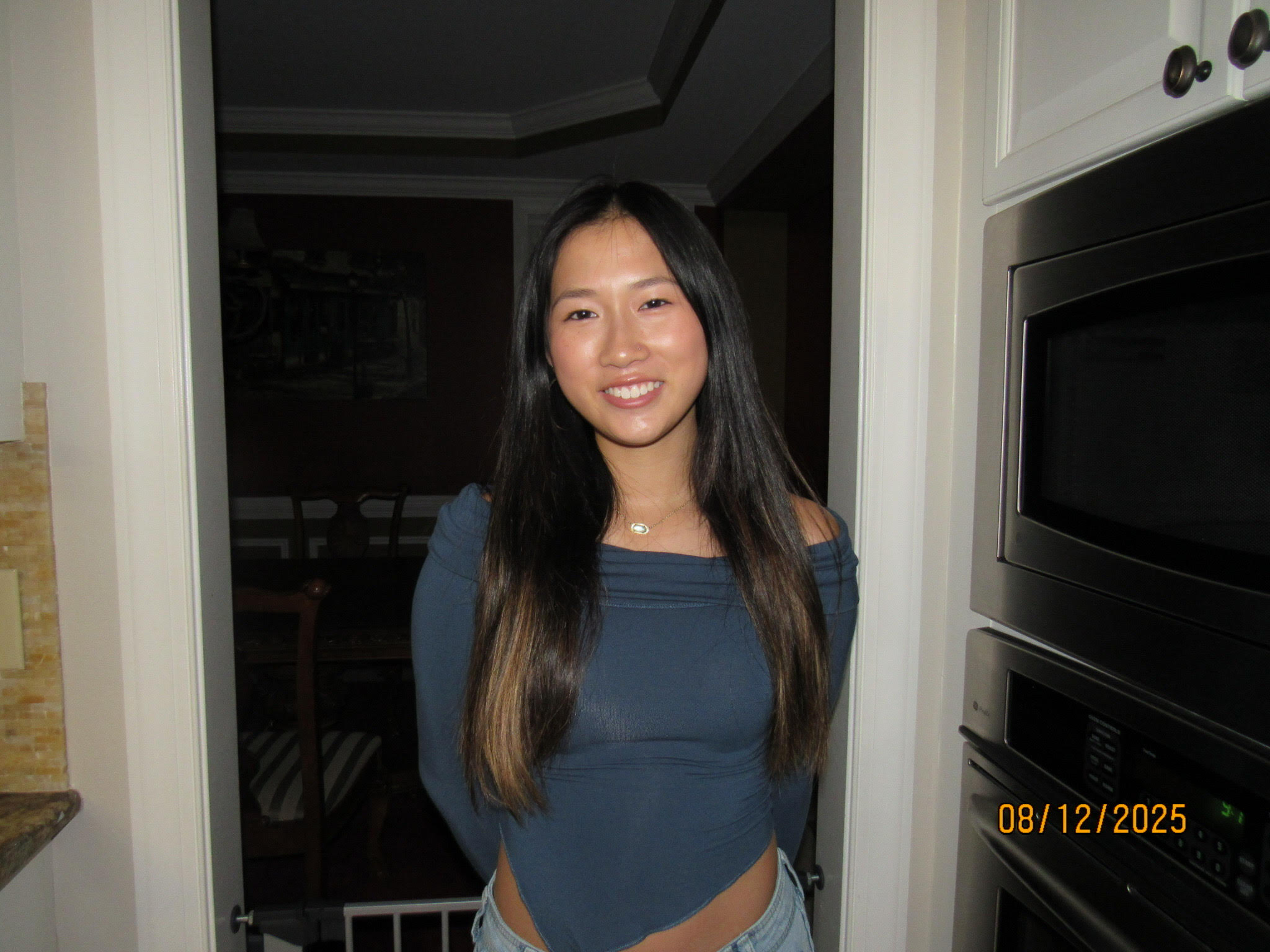 A digital photo dated 8/12/2025 of jeslyn in a kitchen