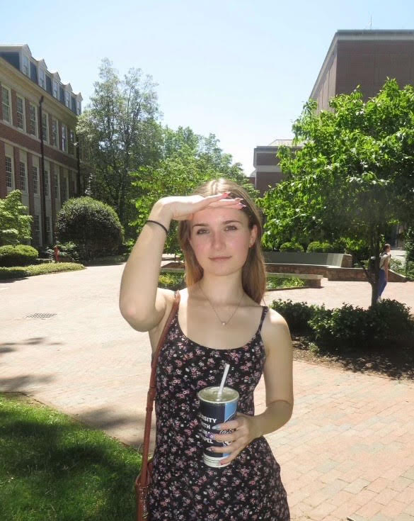 Julie holding a cup on UNC campus looking at the camera